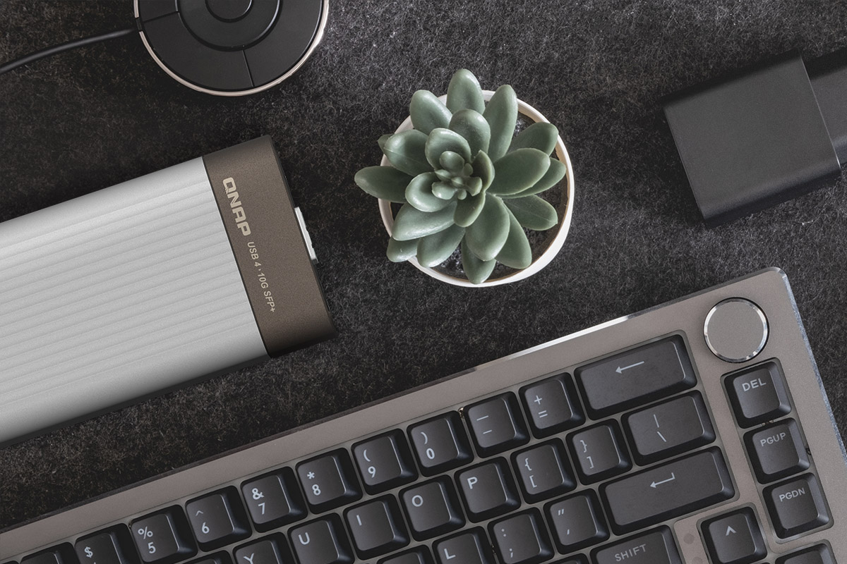 QNAP QNA-UC10G1SF compact metal adapter on a professional workstation desk