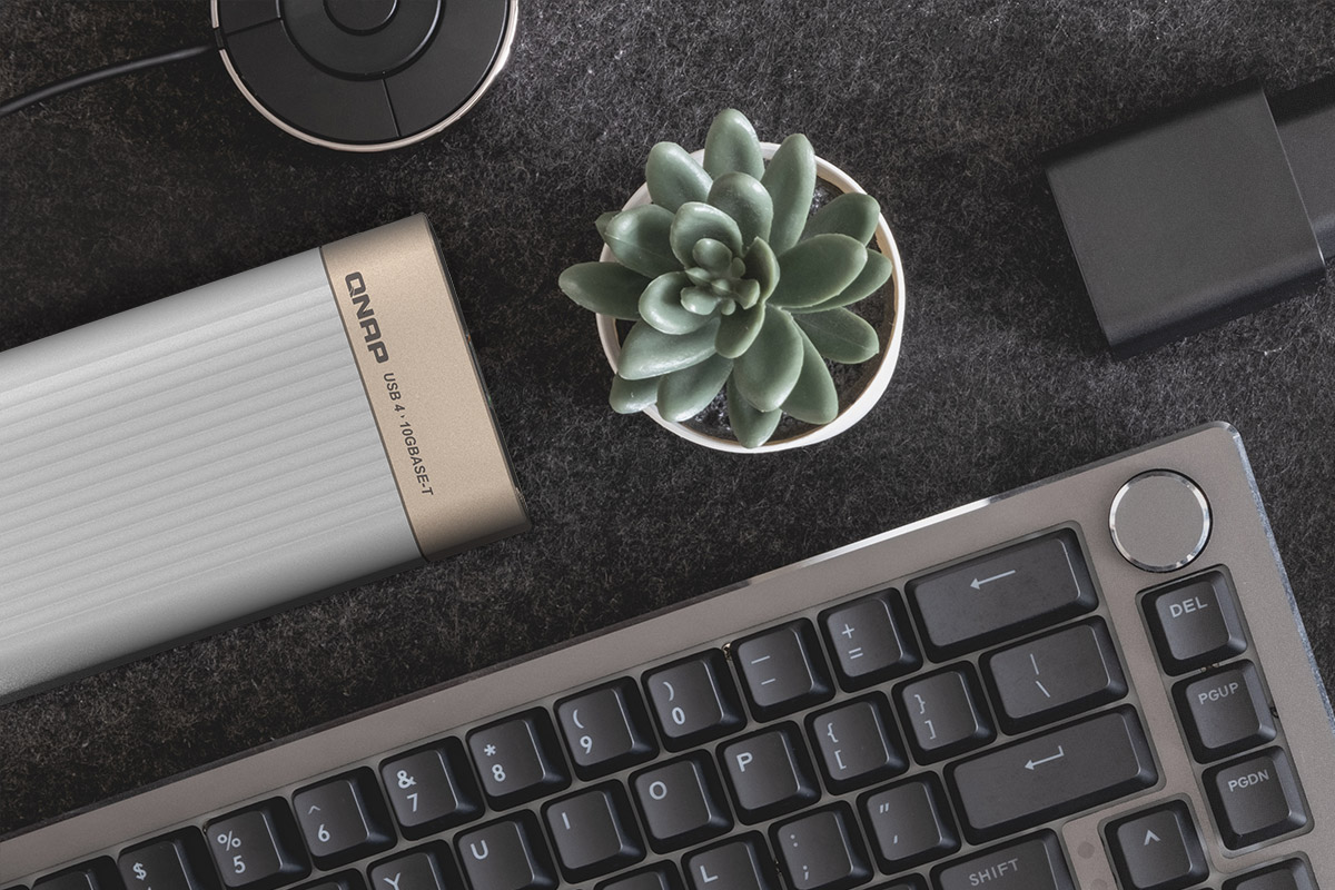 QNAP QNA-UC10G1T compact metal adapter on workstation desk